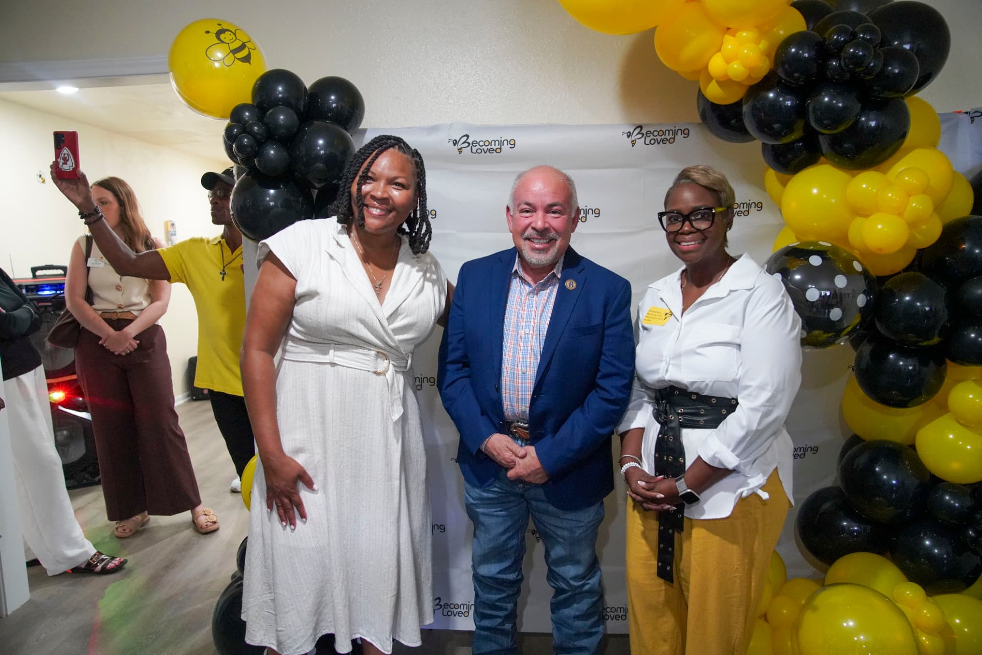 Three attendees posing together at the ribbon-cutting celebration